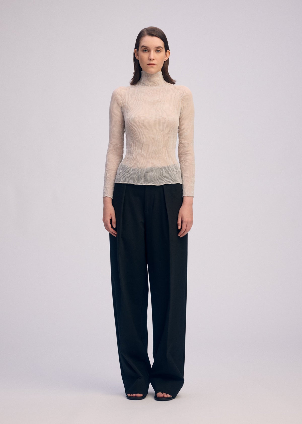 A model wears the ISSEY MIYAKE CHIFFON TWIST 3 shirt.