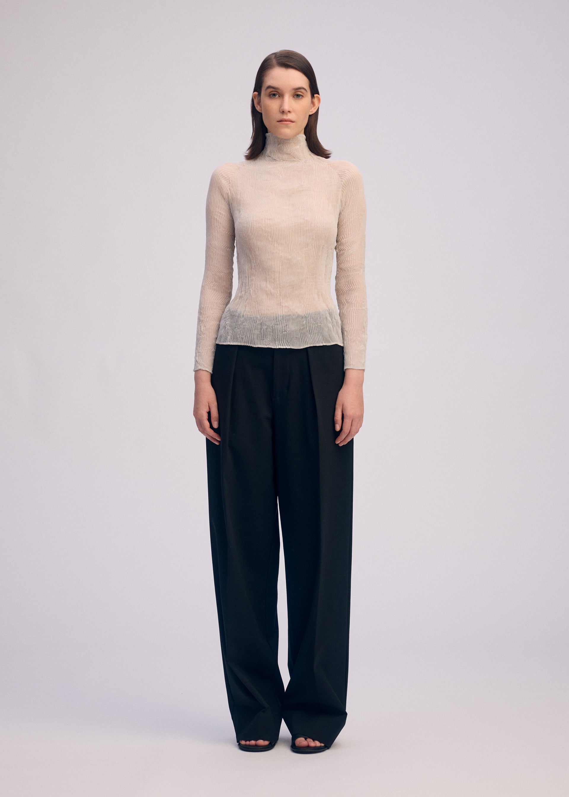 A model wears the ISSEY MIYAKE CHIFFON TWIST 3 shirt.