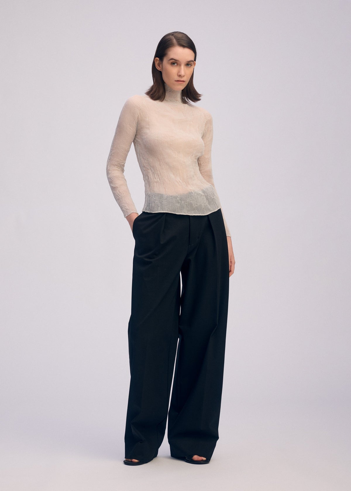 A model wears the ISSEY MIYAKE CHIFFON TWIST 3 shirt.