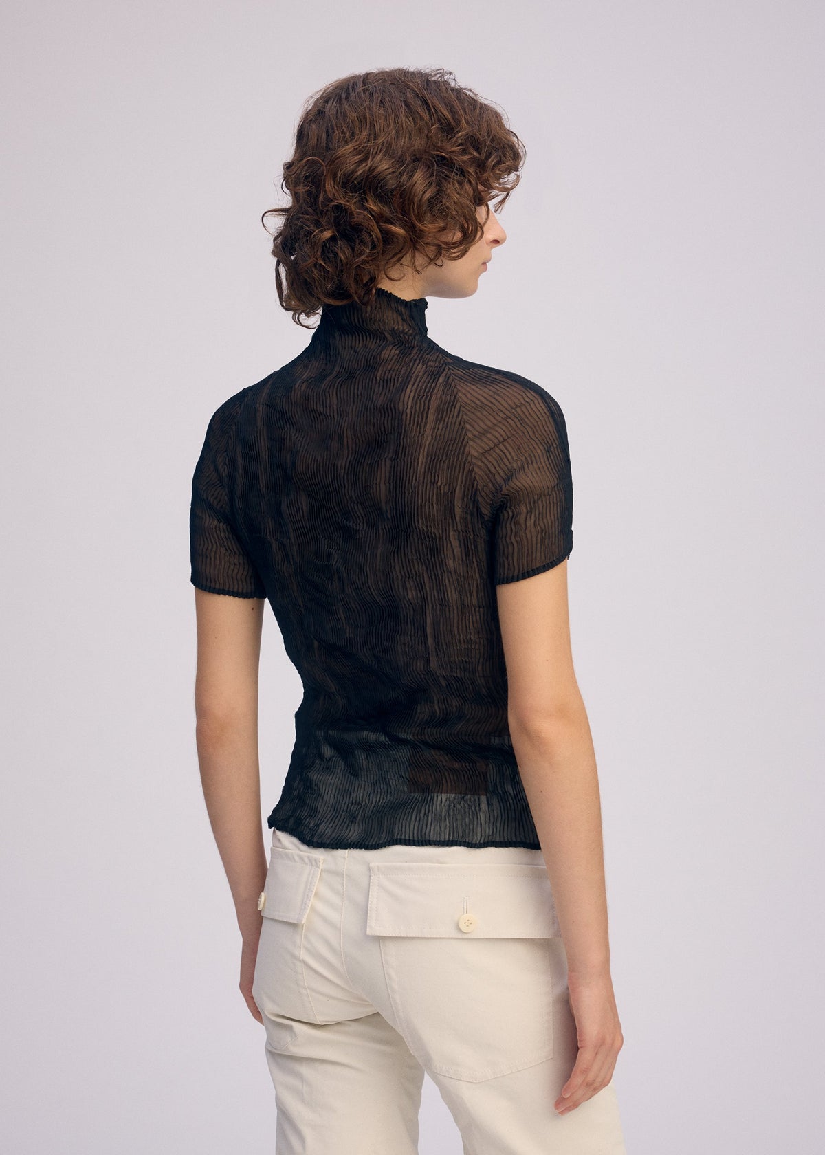 A model wears the Issey Miyake CHIFFON TWIST BKWT 66 shirt.