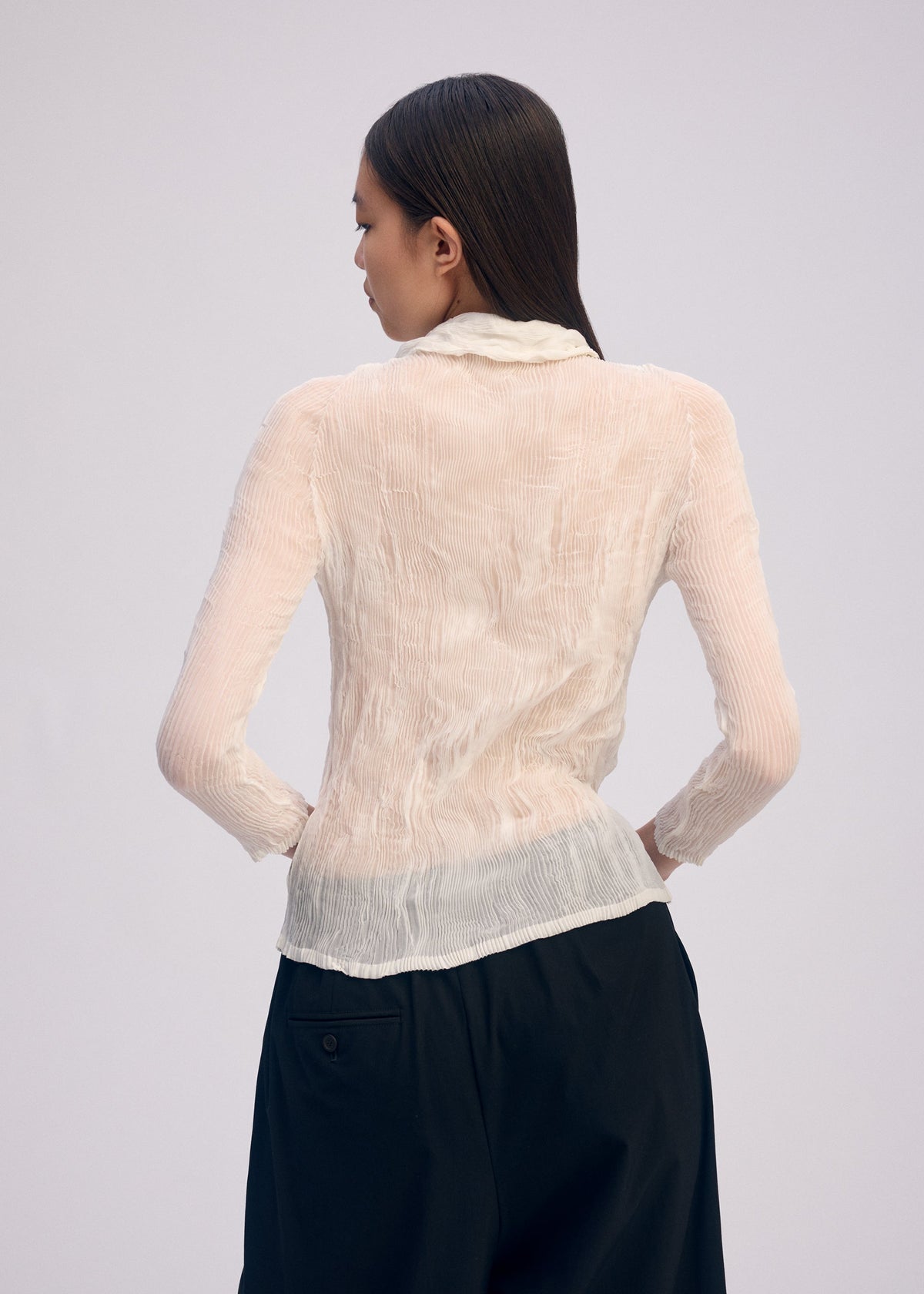 A model wears the Issey Miyake CHIFFON TWIST BKWT 66 shirt.