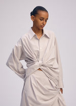 A model wears the ISSEY MIYAKE TWISTED DRAPE shirt.