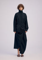 A model wears the ISSEY MIYAKE TWISTED DRAPE shirt.
