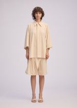A model wears the Issey Miyake LOOPED shirt.