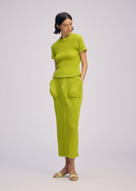 A model wears the ISSEY MIYAKE WAVELET ENSEMBLE shirt.