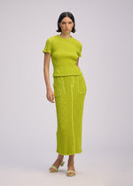 A model wears the ISSEY MIYAKE WAVELET ENSEMBLE shirt.