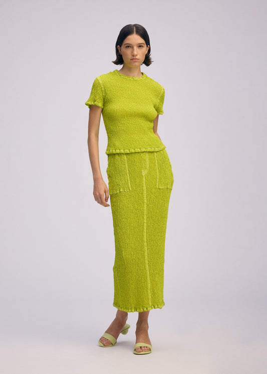 A model wears the ISSEY MIYAKE WAVELET ENSEMBLE shirt.