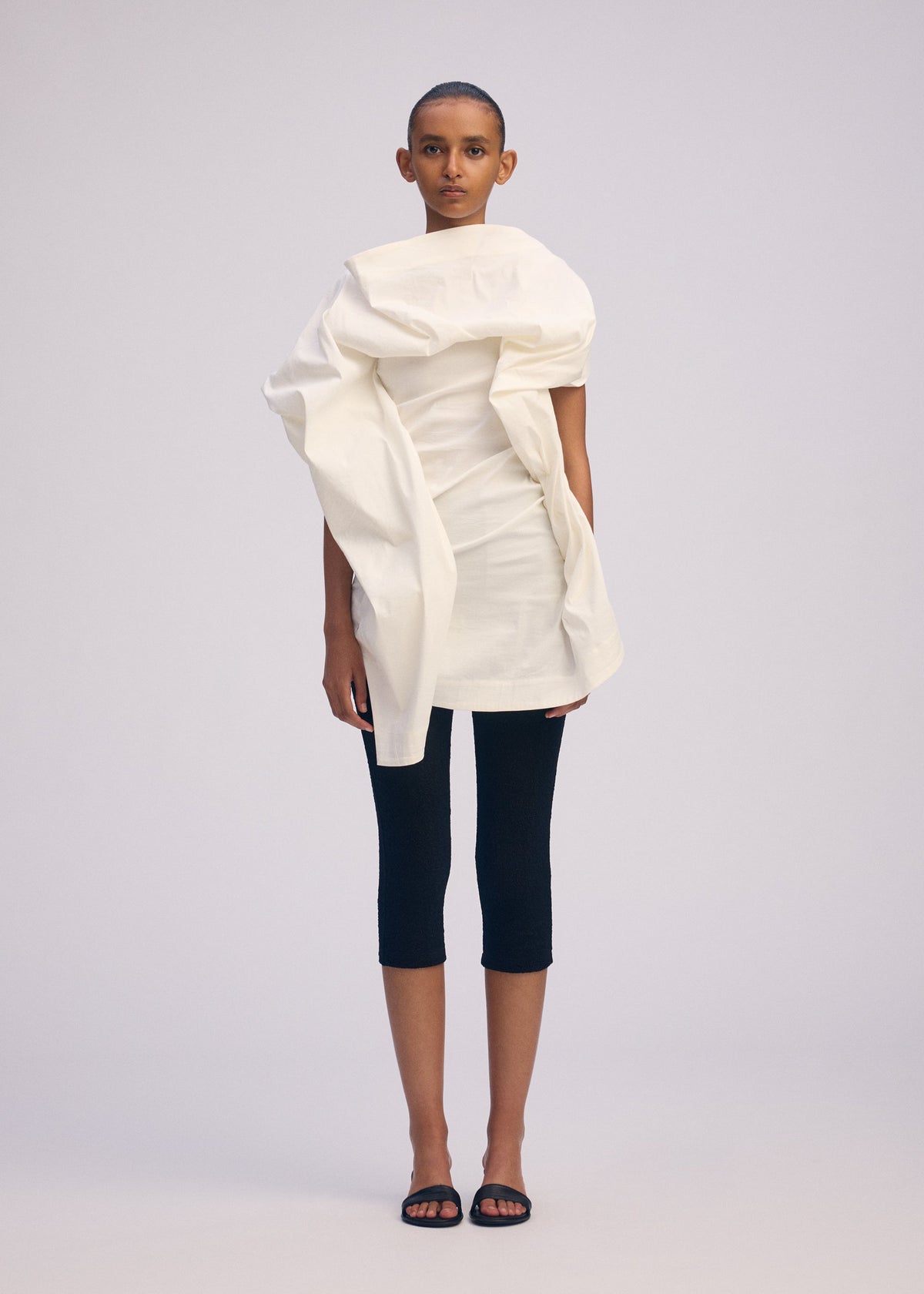 A model wears the ISSEY MIYAKE CONCEALED concealed-shirt-white.