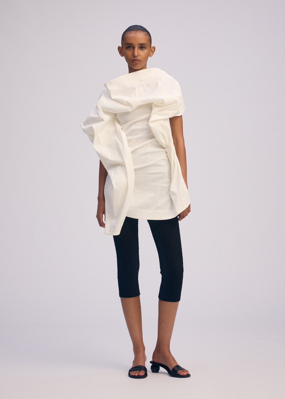 A model wears the ISSEY MIYAKE CONCEALED concealed-shirt-white.