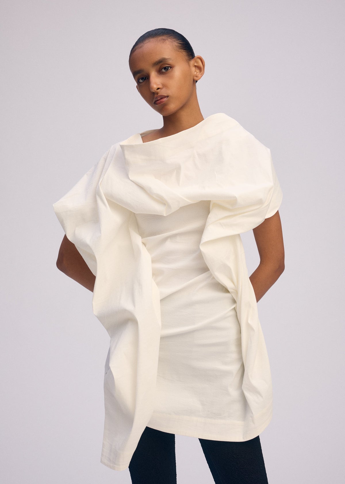 A model wears the ISSEY MIYAKE CONCEALED concealed-shirt-white.