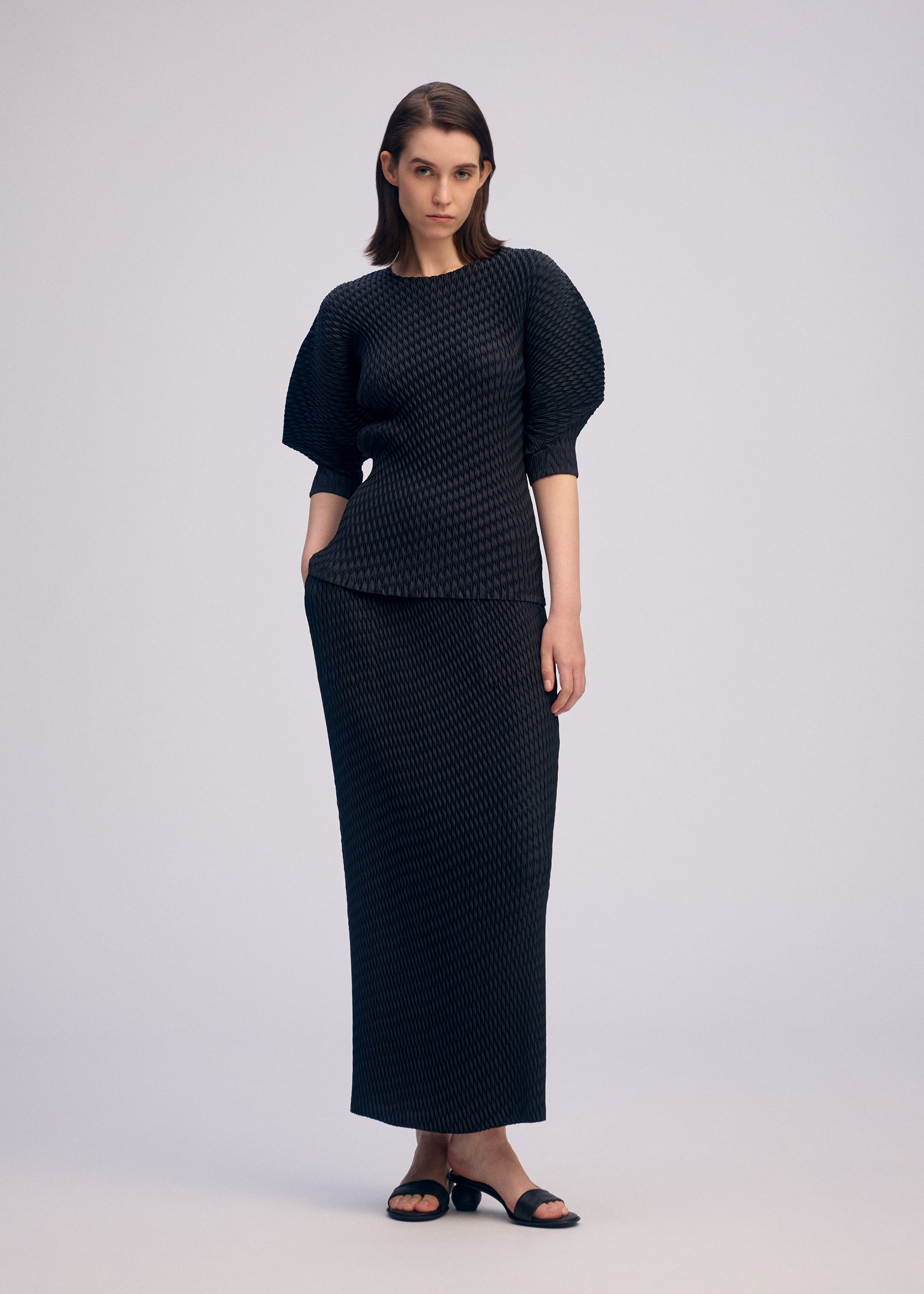 A model wears the ISSEY MIYAKE SLEEK PLEATS sleek-pleats-shirt-black-3.