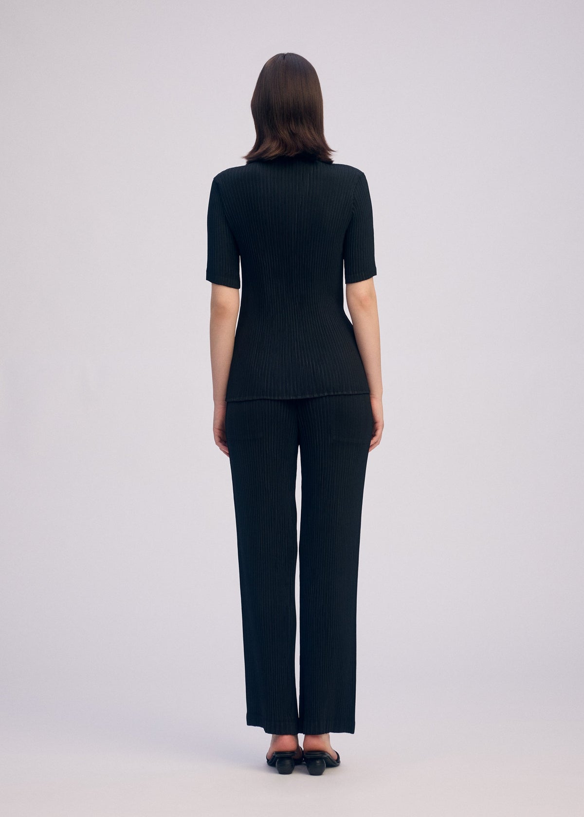 A model wears the ISSEY MIYAKE HATCHING PLEATS prêt à porter.