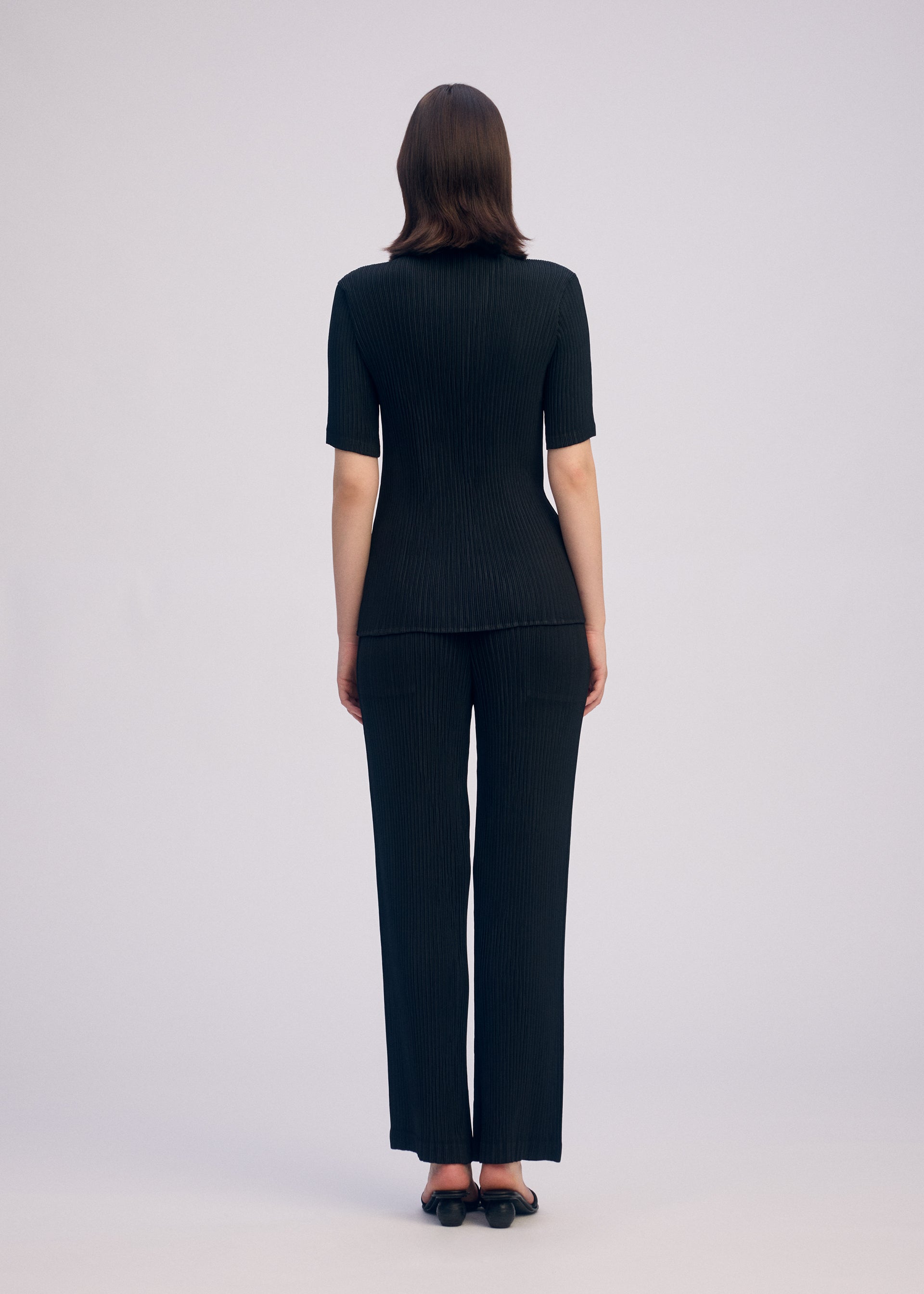 A model wears the ISSEY MIYAKE HATCHING PLEATS prêt à porter.