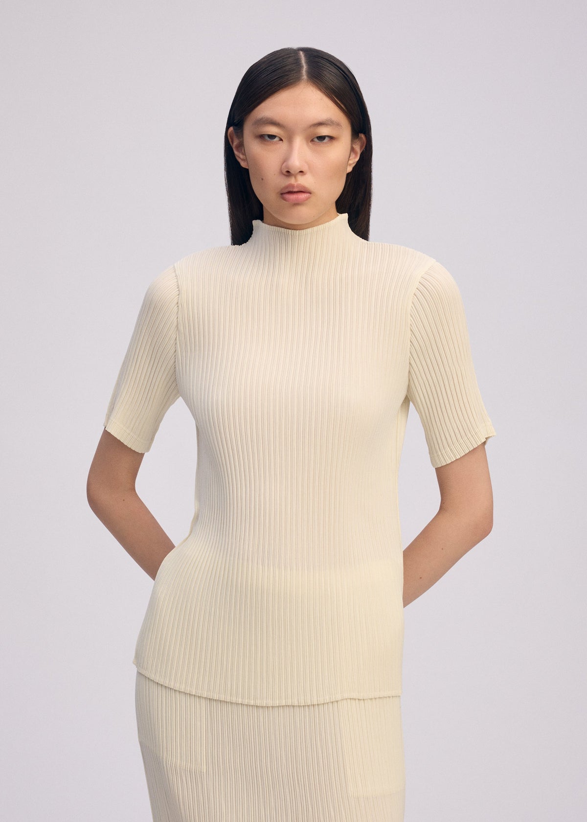 A model wears the ISSEY MIYAKE HATCHING PLEATS prêt à porter.