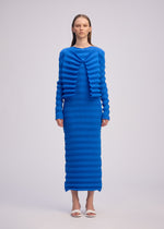 A model wears the ISSEY MIYAKE SPRING PLEATS spring-pleats-cardigan-starling-blue.