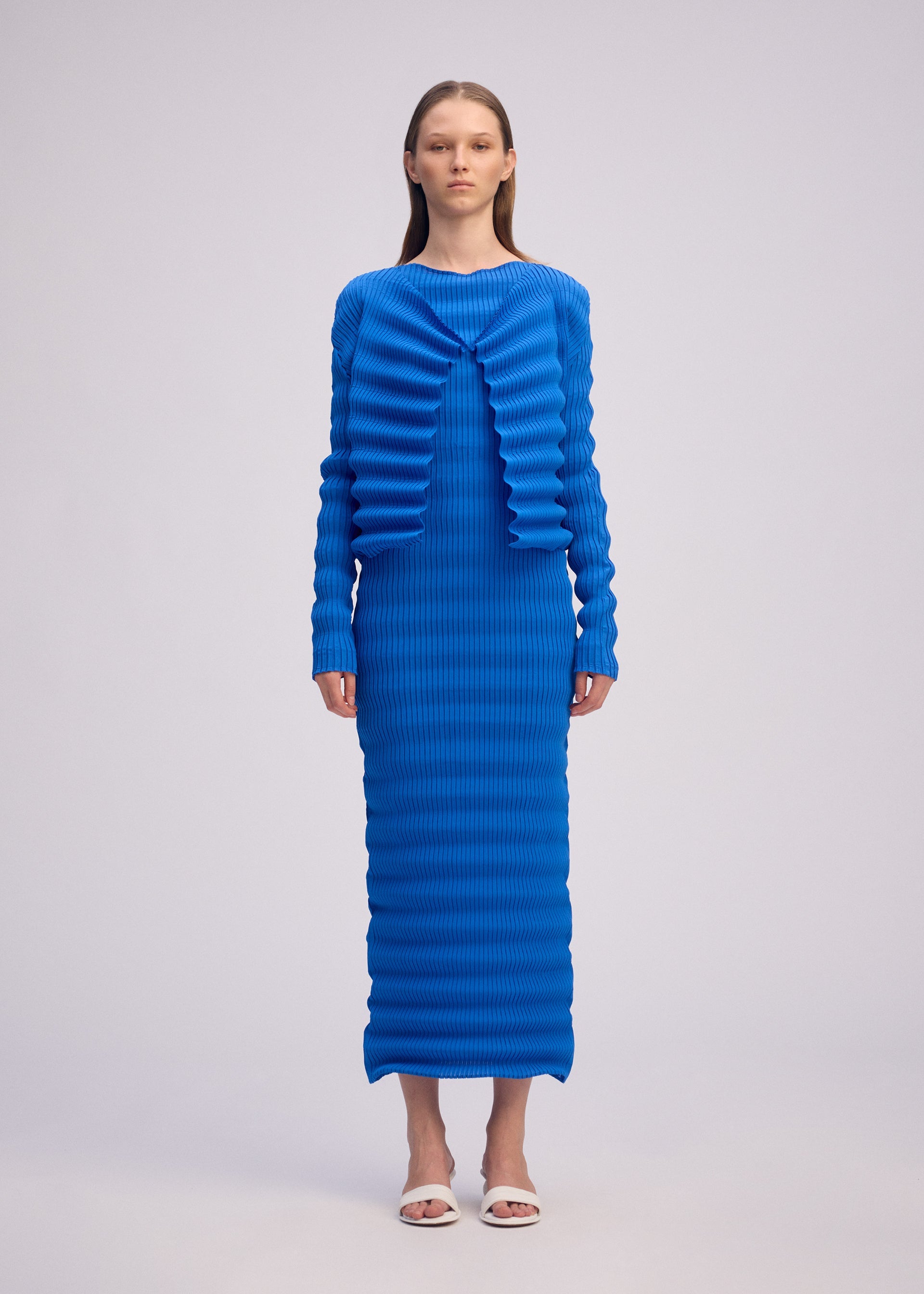 A model wears the ISSEY MIYAKE SPRING PLEATS spring-pleats-cardigan-starling-blue.