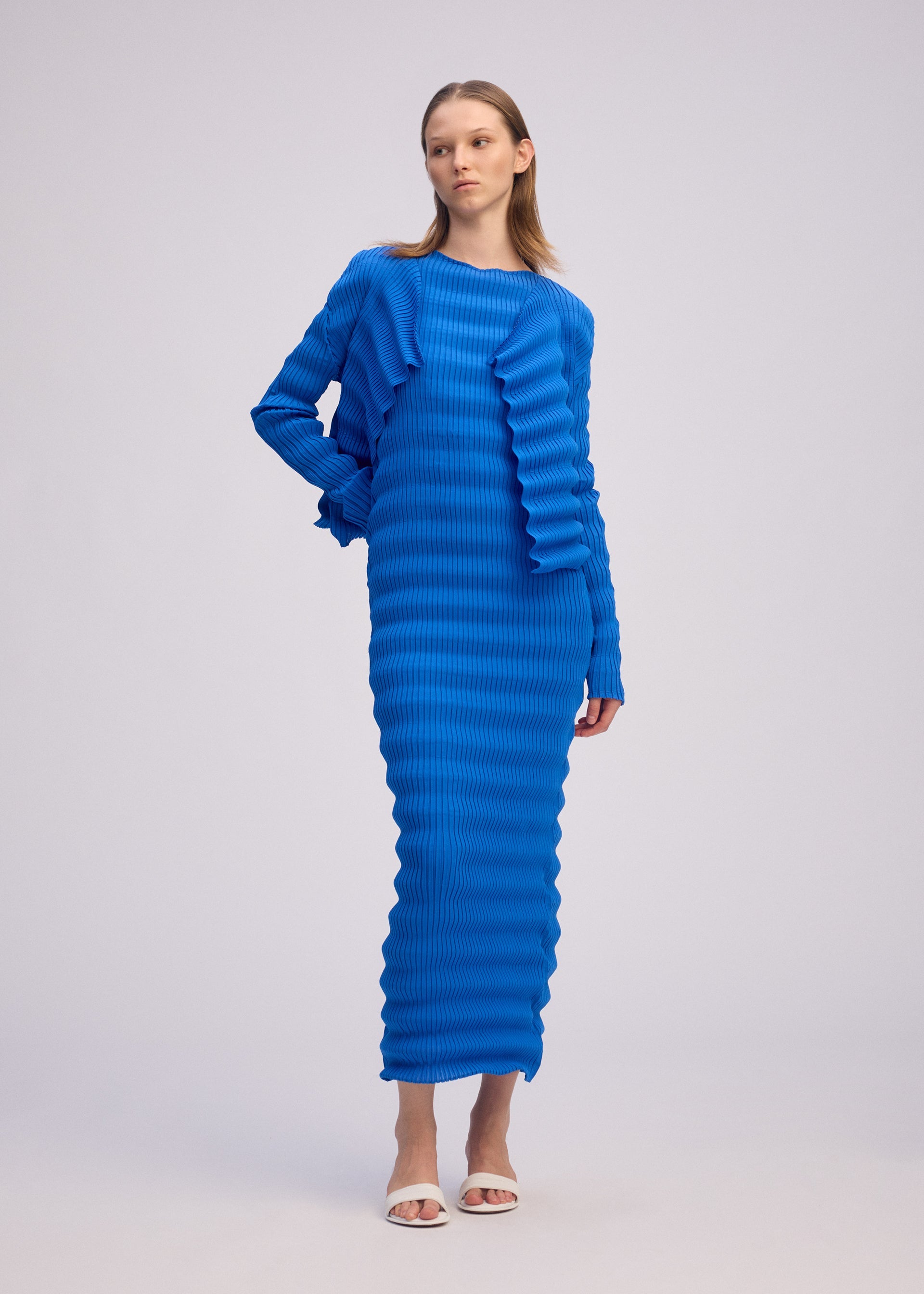 A model wears the ISSEY MIYAKE SPRING PLEATS spring-pleats-cardigan-starling-blue.
