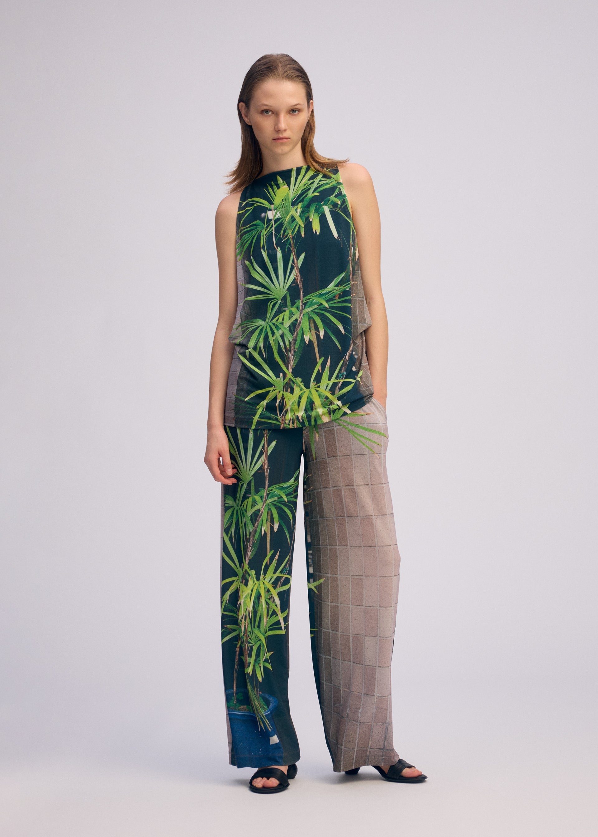 A model wears the Issey Miyake URBAN JUNGLE JERSEY pants.