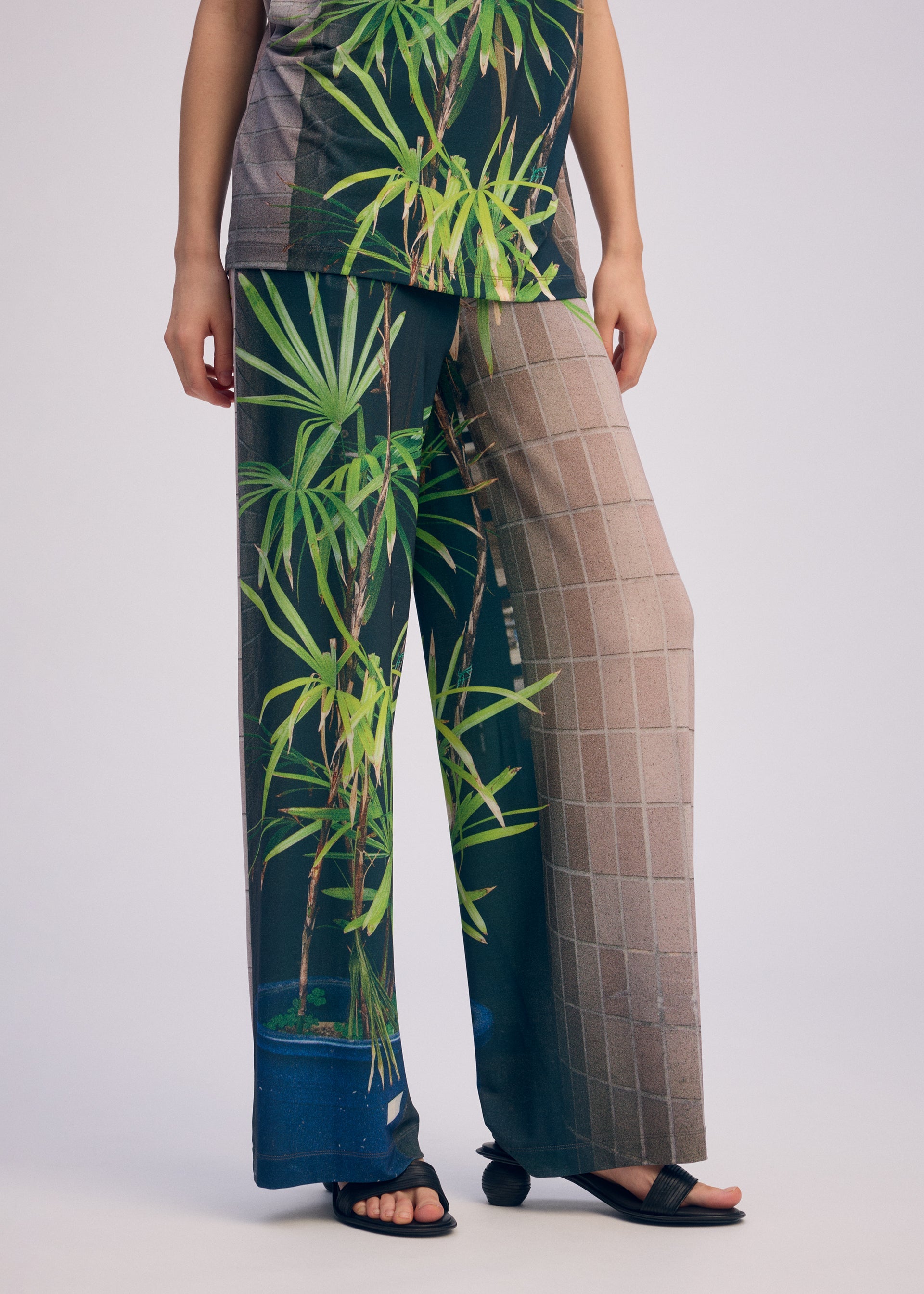 A model wears the Issey Miyake URBAN JUNGLE JERSEY pants.