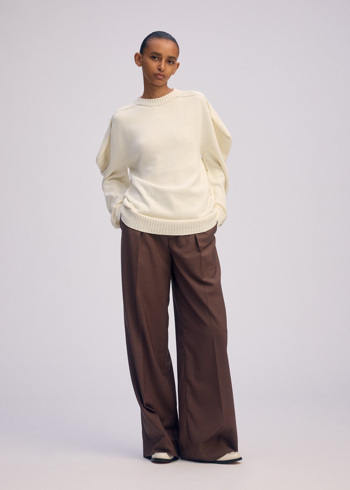 A model wears the ISSEY MIYAKE AKIMBO KNIT prêt à porter.
