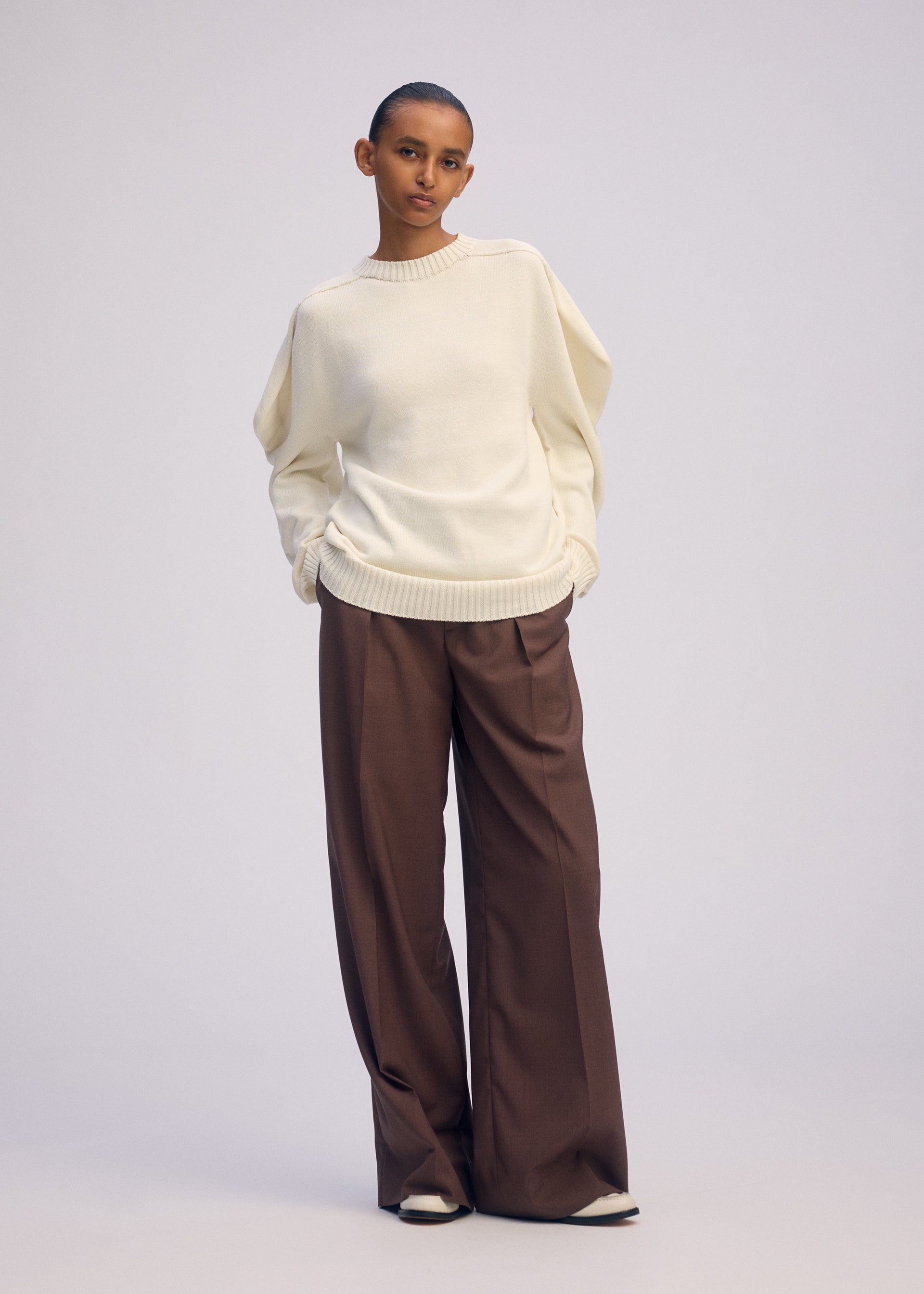 A model wears the ISSEY MIYAKE AKIMBO KNIT prêt à porter.