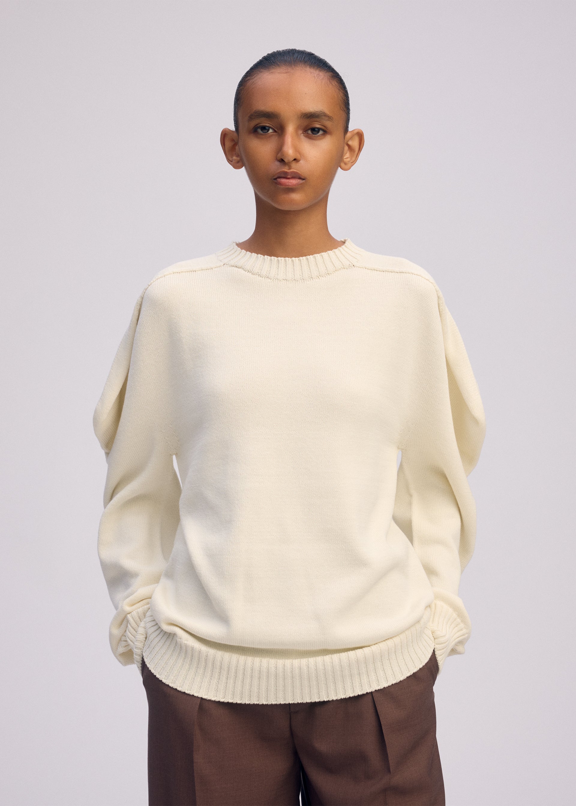 A model wears the ISSEY MIYAKE AKIMBO KNIT prêt à porter.