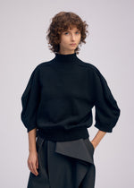 A model wears the ISSEY MIYAKE AKIMBO KNIT prêt à porter.