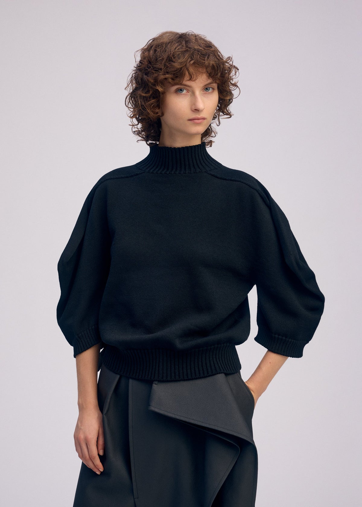 A model wears the ISSEY MIYAKE AKIMBO KNIT prêt à porter.