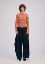 A model wears the ISSEY MIYAKE BELT LOOP KNIT top.