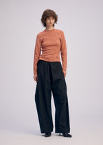 A model wears the ISSEY MIYAKE BELT LOOP KNIT top.