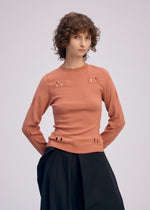 A model wears the ISSEY MIYAKE BELT LOOP KNIT top.