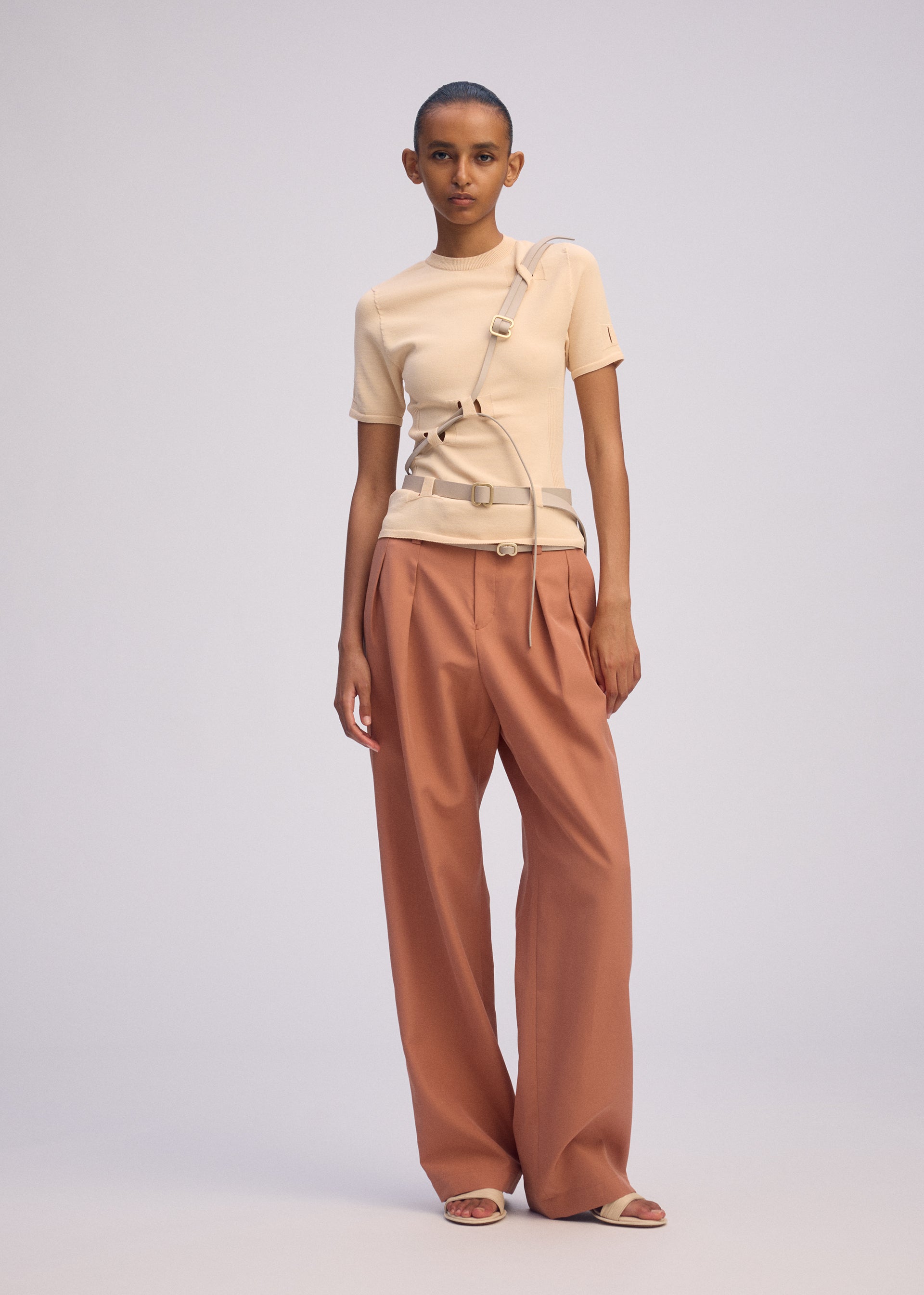A model wears the ISSEY MIYAKE BELT LOOP KNIT top.
