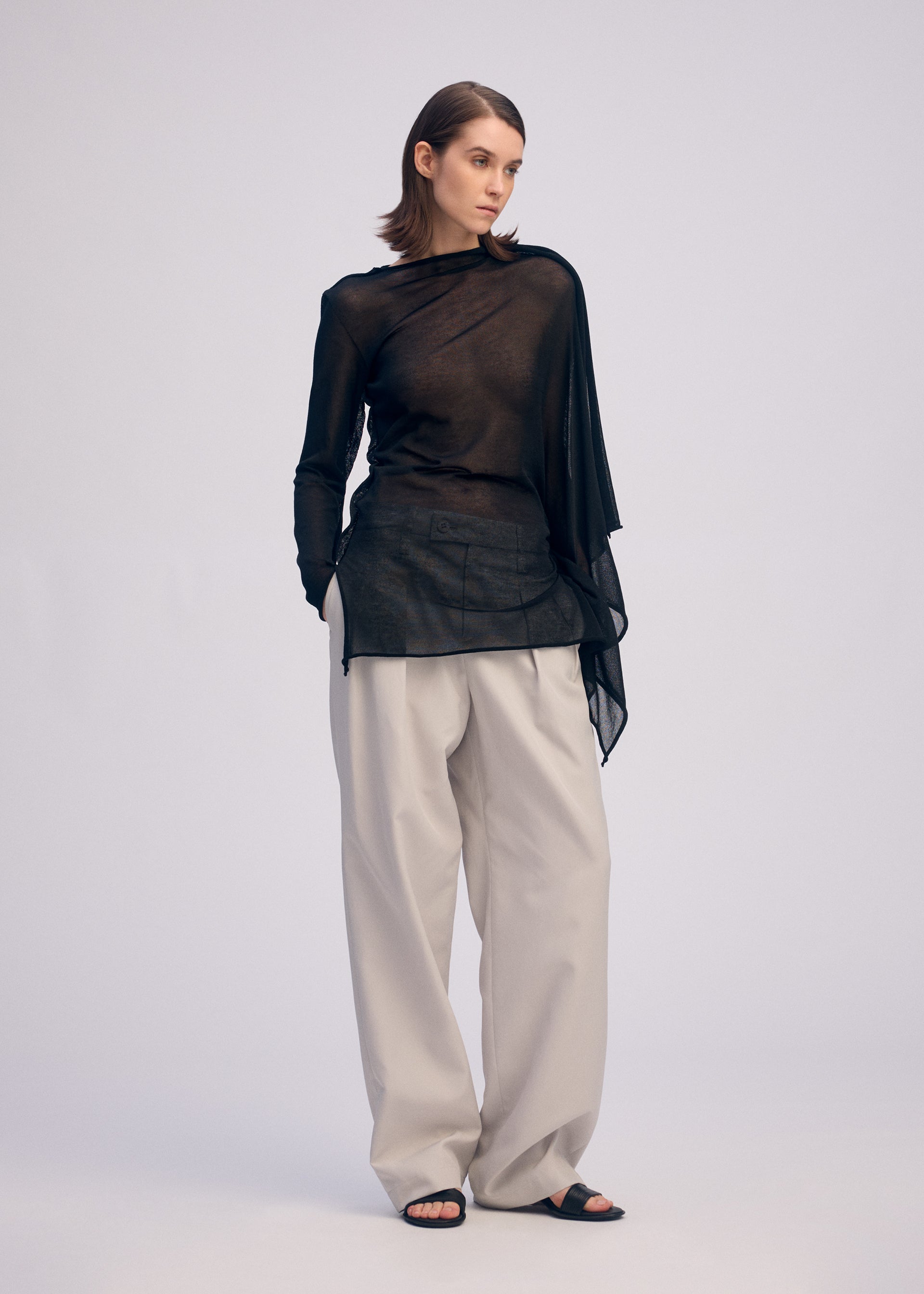 A model wears the ISSEY MIYAKE CONCEALED KNIT concealed-knit-top-light-grey.