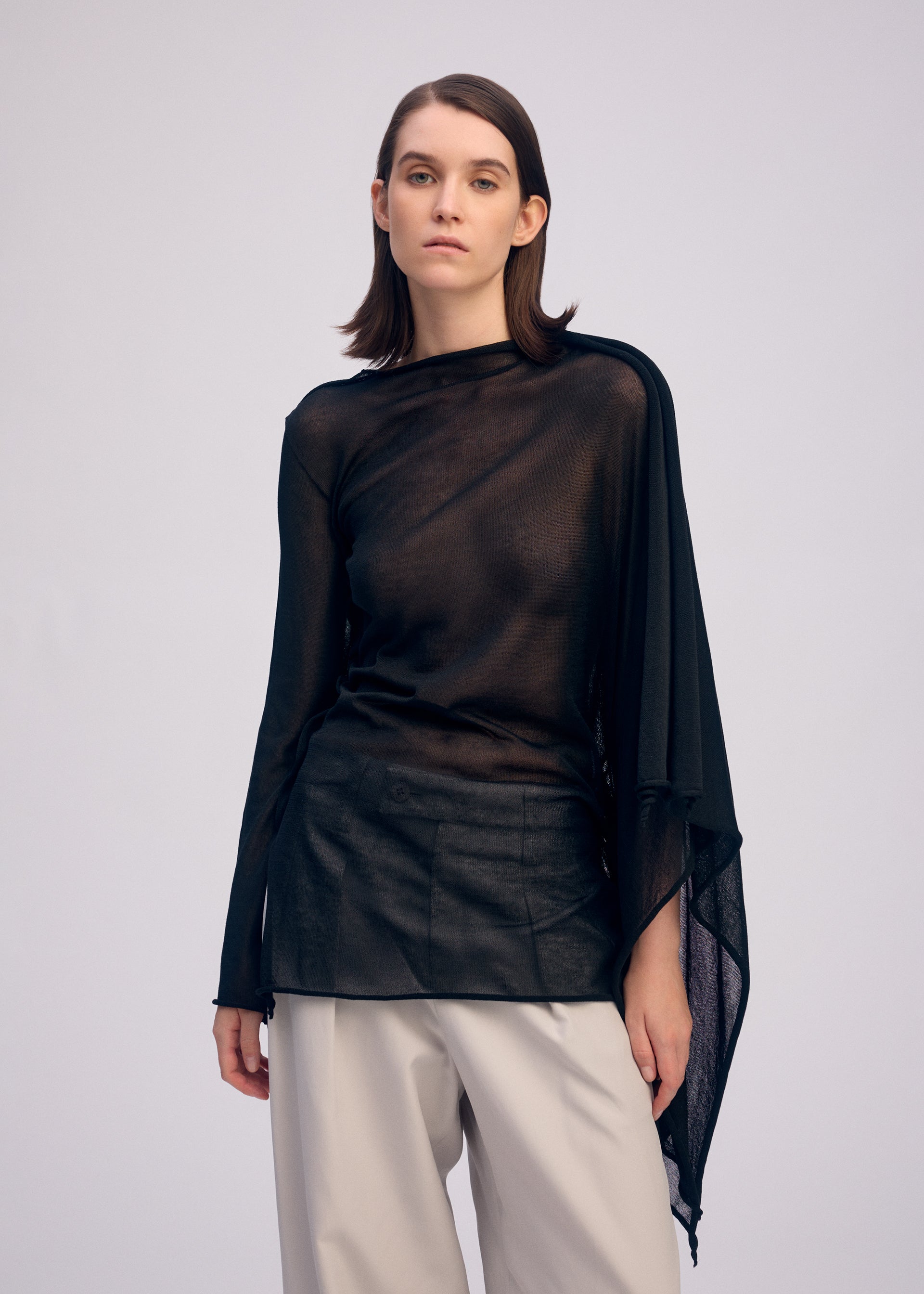 A model wears the ISSEY MIYAKE CONCEALED KNIT concealed-knit-top-light-grey.