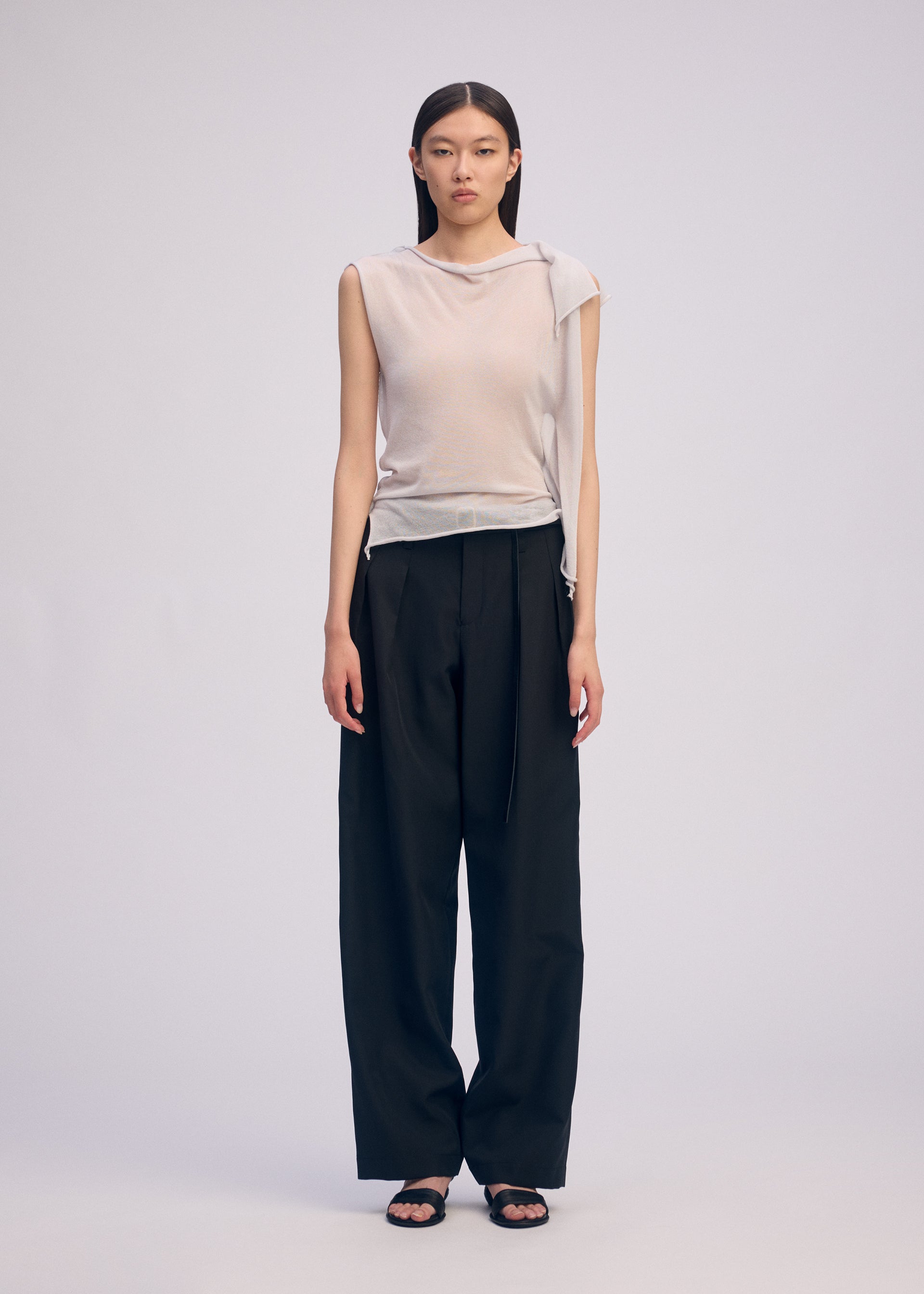 A model wears the ISSEY MIYAKE CONCEALED KNIT concealed-knit-top-light-grey-1.