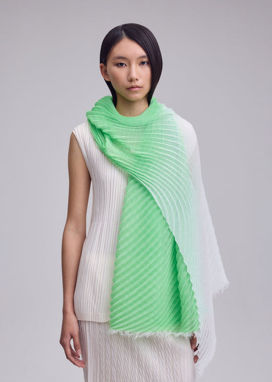 A model wears the ISSEY MIYAKE GRADATION RAMIE PLEATS STOLE gradation-ramie-pleats-stole-stole-green-hued-2.