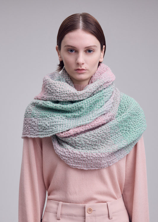 A model wears the ISSEY MIYAKE BUMPY WOOL STOLE stole.