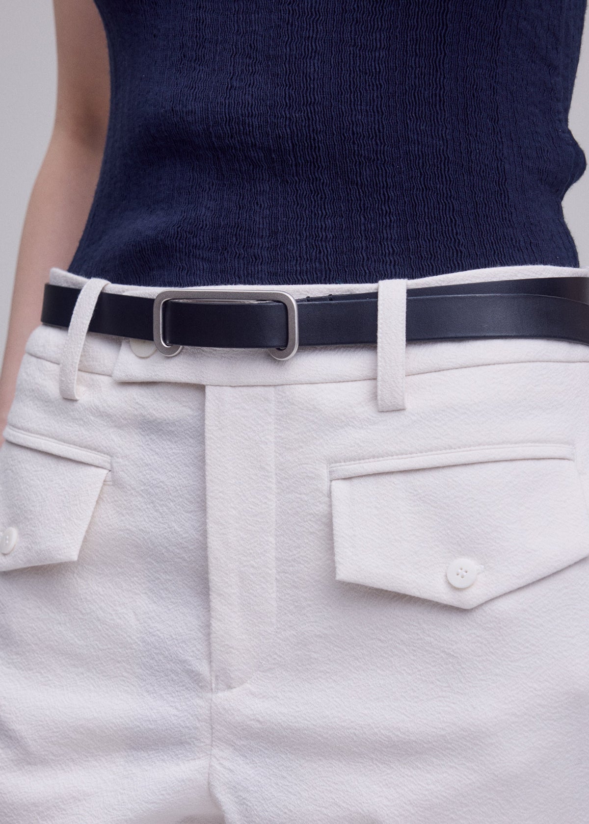 A model wears the ISSEY MIYAKE SOLID LEATHER BELT solid-leather-belt-belt-dark-brown-3.