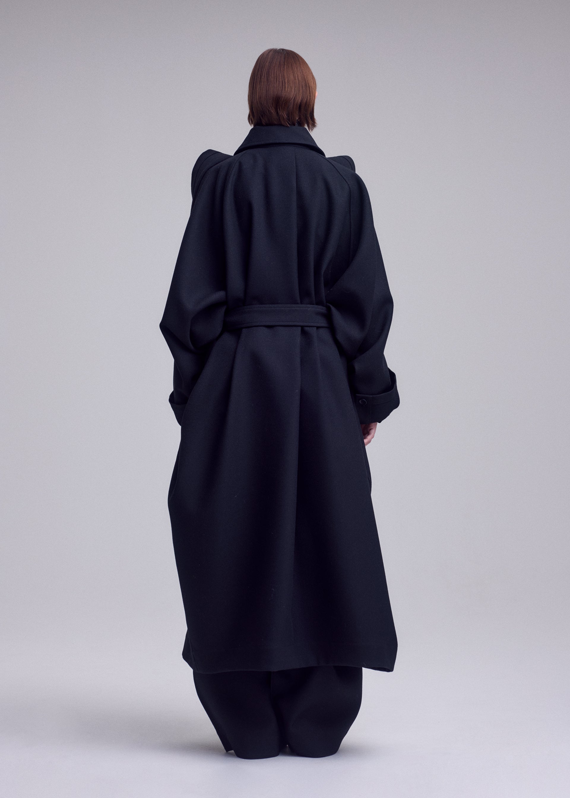 A model wears the ISSEY MIYAKE CALLIGRAPH coat.