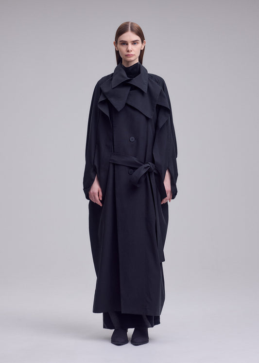 A model wears the ISSEY MIYAKE HANDS OF LOVER coat.