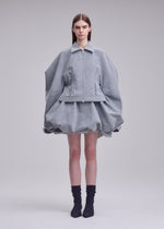 A model wears the ISSEY MIYAKE REFLECTION blouson.