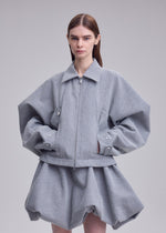A model wears the ISSEY MIYAKE REFLECTION blouson.
