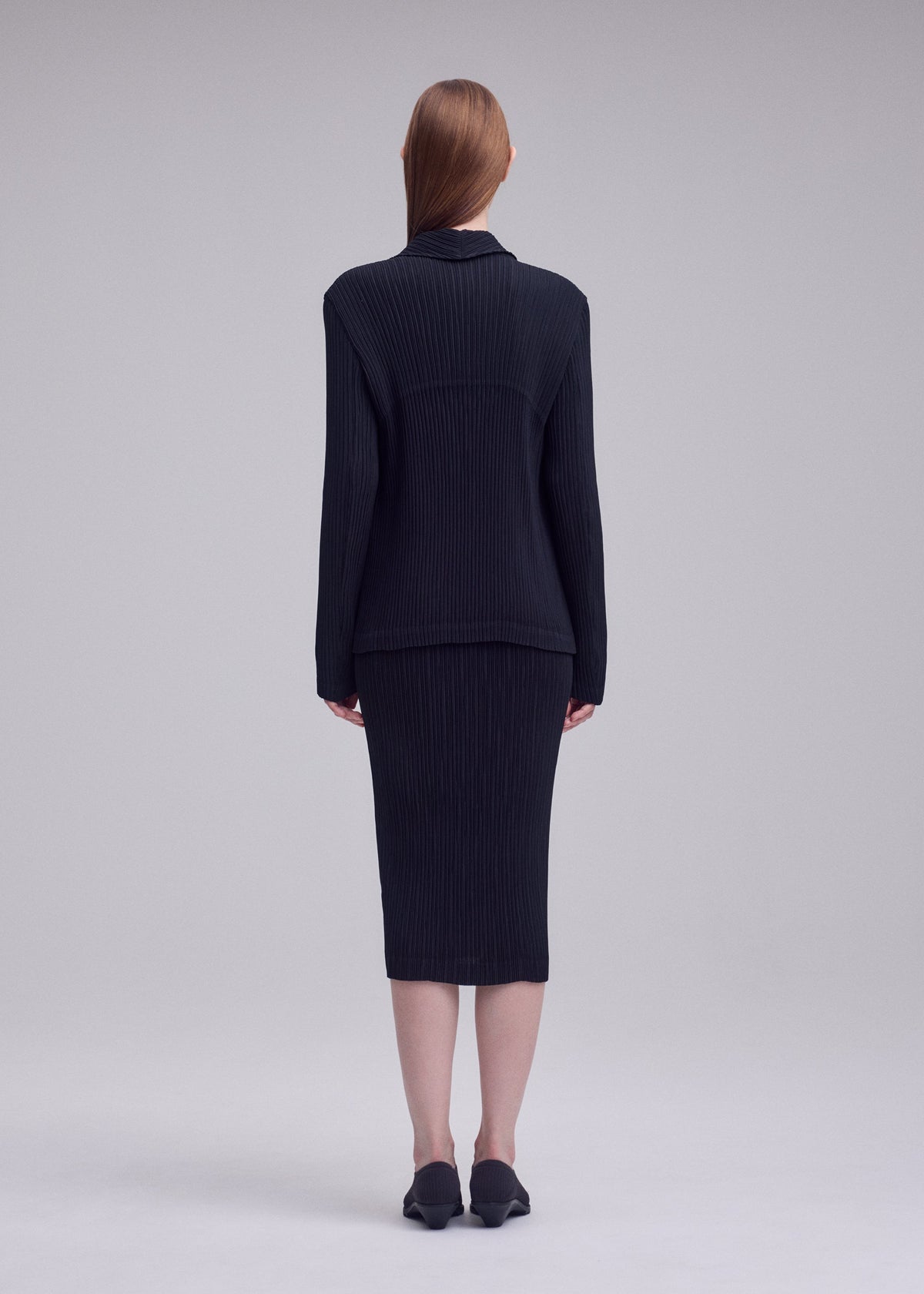 A model wears the ISSEY MIYAKE HATCHING PLEATS jacket.