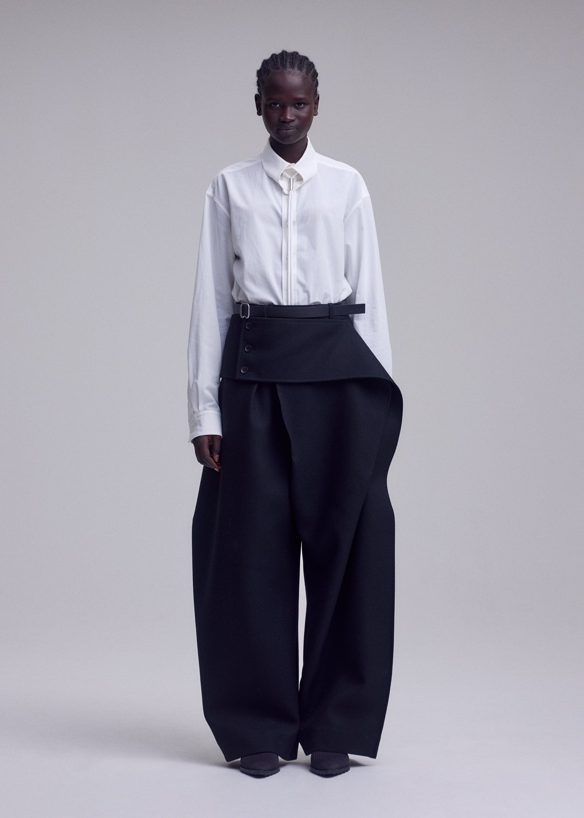 A model wears the ISSEY MIYAKE CALLIGRAPH trousers.