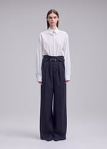 A model wears the ISSEY MIYAKE HONEST ENSEMBLE honest-ensemble-trousers-grey.