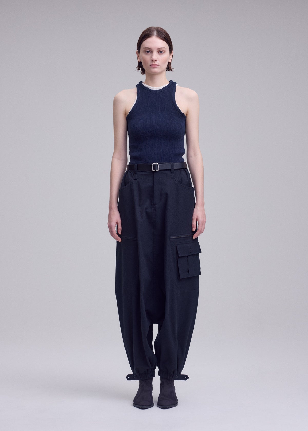 A model wears the ISSEY MIYAKE GRAINY PANTS grainy-trousers-trousers-black-1.
