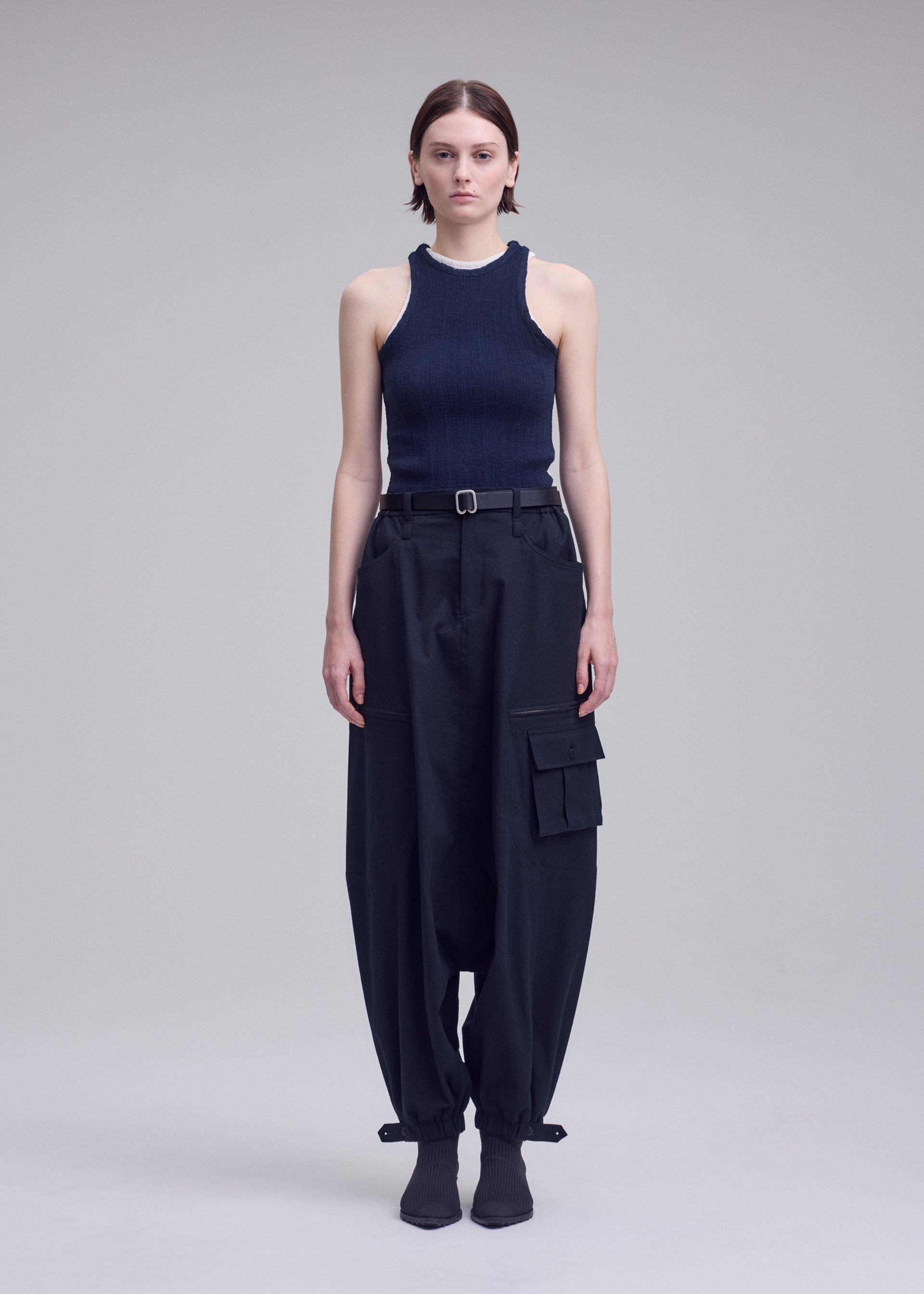 A model wears the ISSEY MIYAKE GRAINY PANTS grainy-trousers-trousers-black-1.