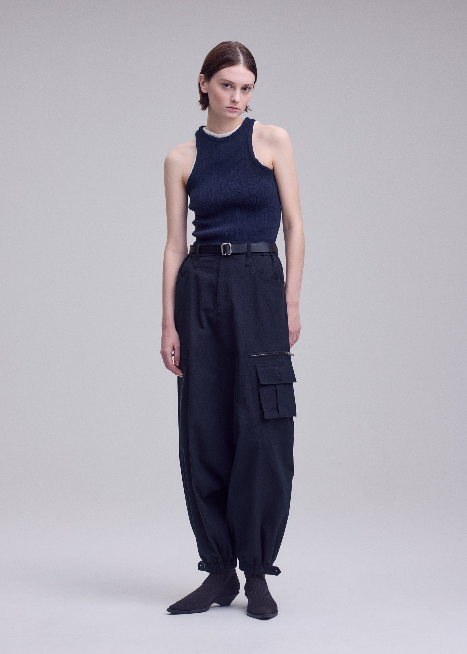 A model wears the ISSEY MIYAKE GRAINY PANTS grainy-trousers-trousers-off-white.