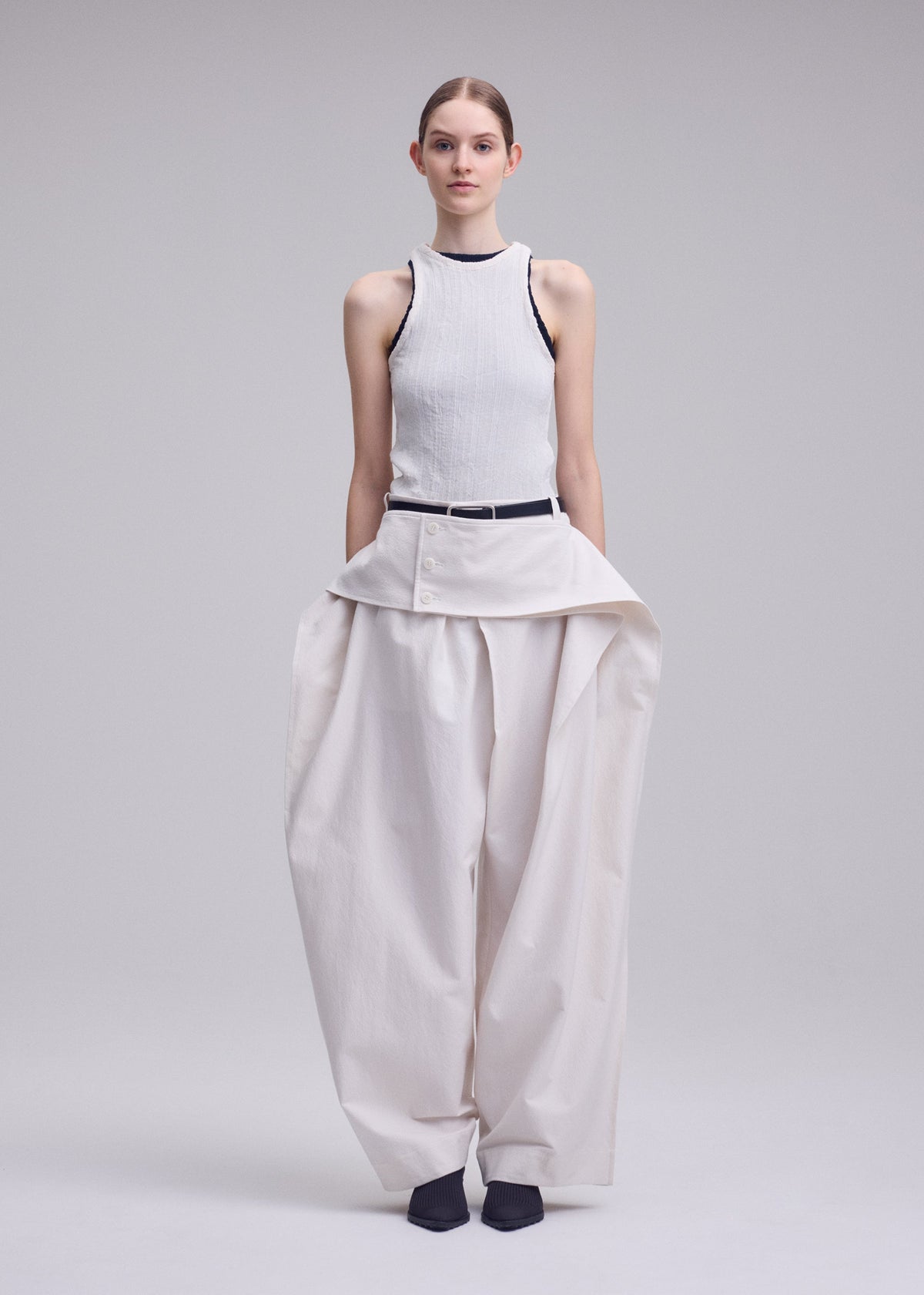 A model wears the ISSEY MIYAKE GRAINY PANTS grainy-trousers-trousers-off-white-2.