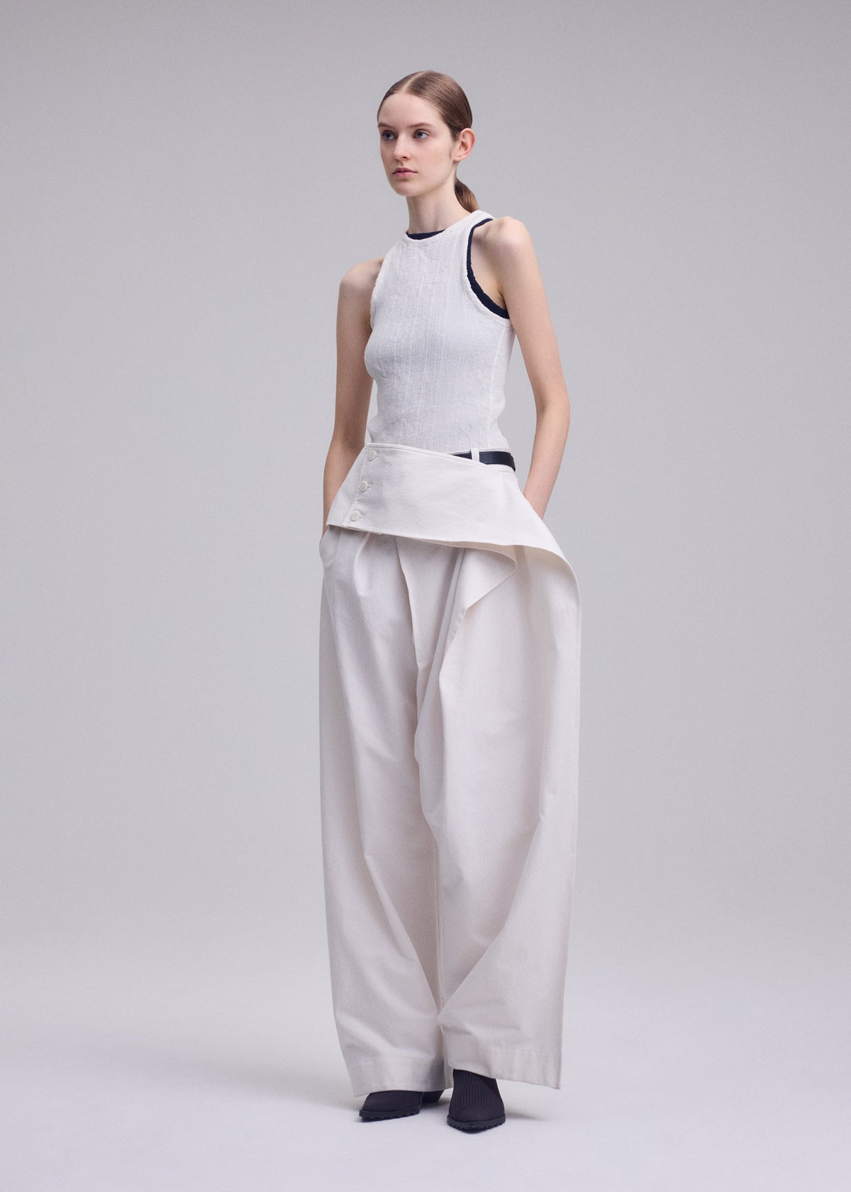 A model wears the ISSEY MIYAKE GRAINY PANTS grainy-trousers-trousers-black-3.